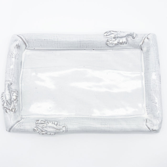 A rectangular clear glass serving tray with a textured silver rim featuring sculpted crawfish details on each corner, shown on a plain white background.